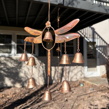 Copper-toned metal dragonfly wind chime with seven small hanging bells suspended by chains