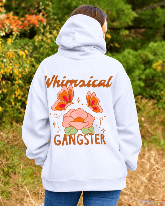 A person viewed from behind wearing a light gray hoodie with a large graphic on the back. The design features the words 'Whimsical GANGSTER' in brown, with orange butterflies and a pink flower with green leaves in the center.