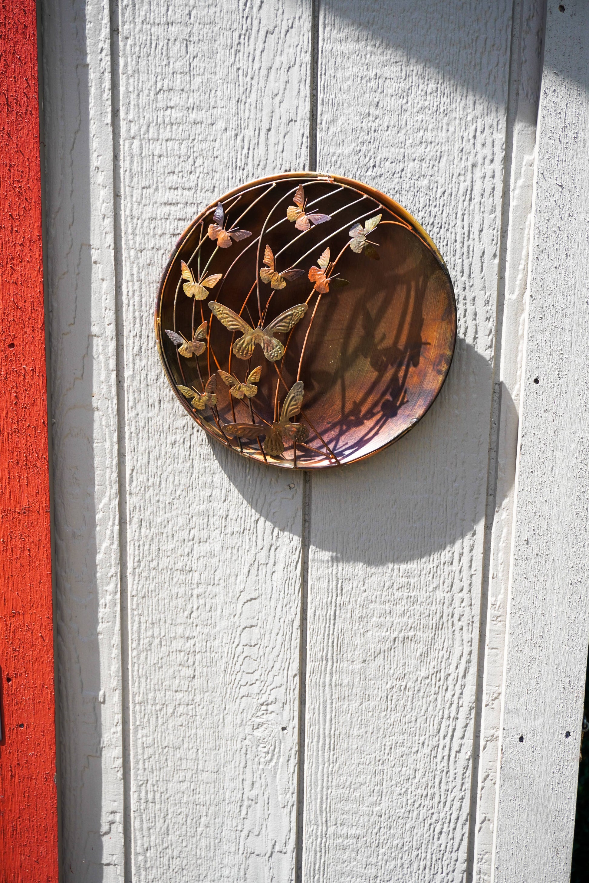 Decorative plate with floral design on a white wooden surface with a red stripe
