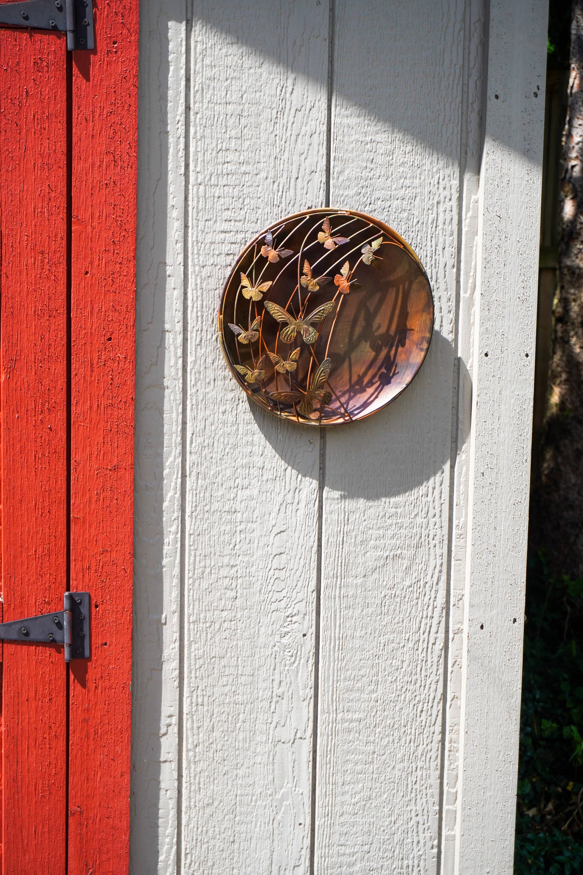 Decorative circular plate on a white wooden door with a red panel