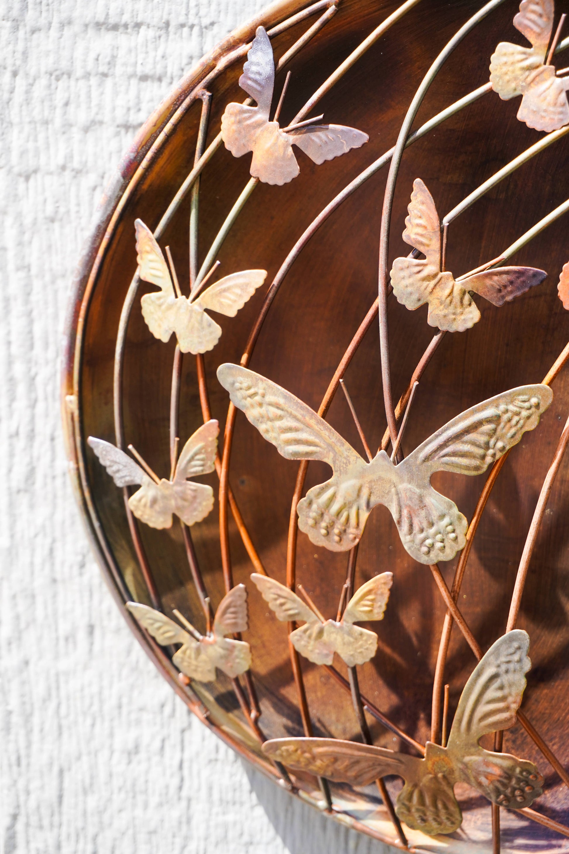Decorative wall art with metal butterflies on a textured surface