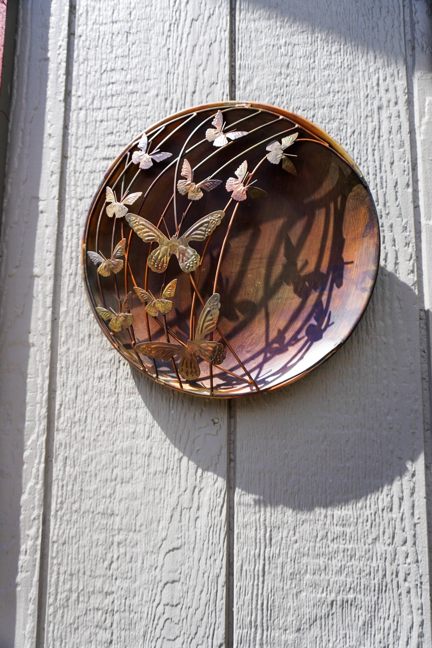 Decorative wall art with butterfly design on a wooden surface