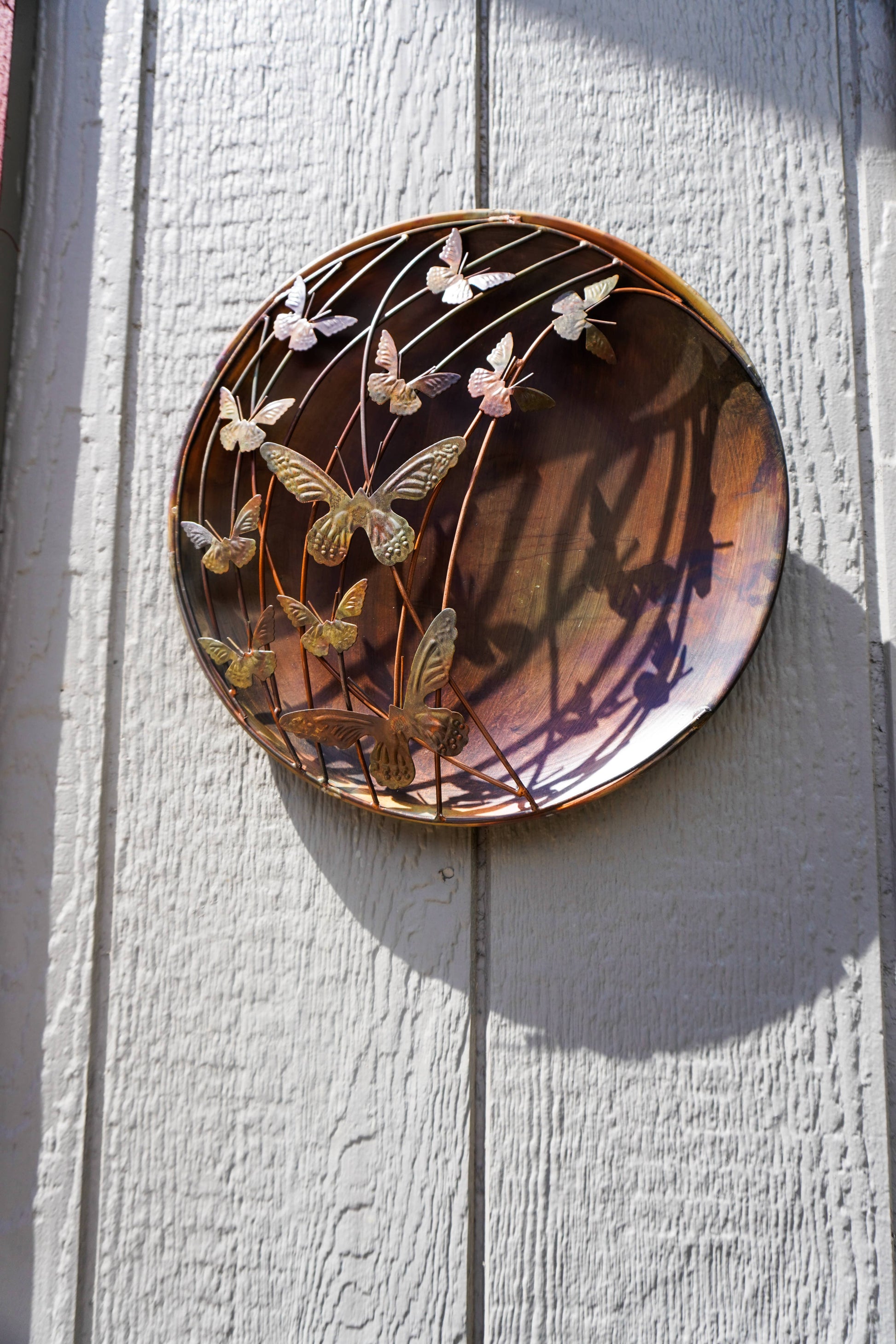Decorative wall art with butterfly design on a wooden surface