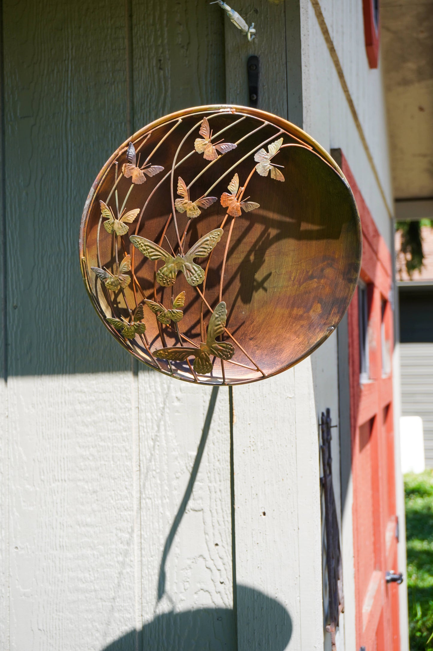 Decorative metal butterfly wall art on a wooden surface
