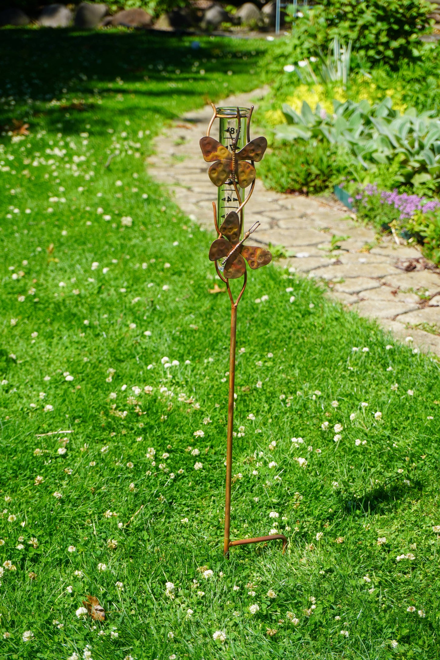 Decorative garden stake with butterfly design on a grassy lawn