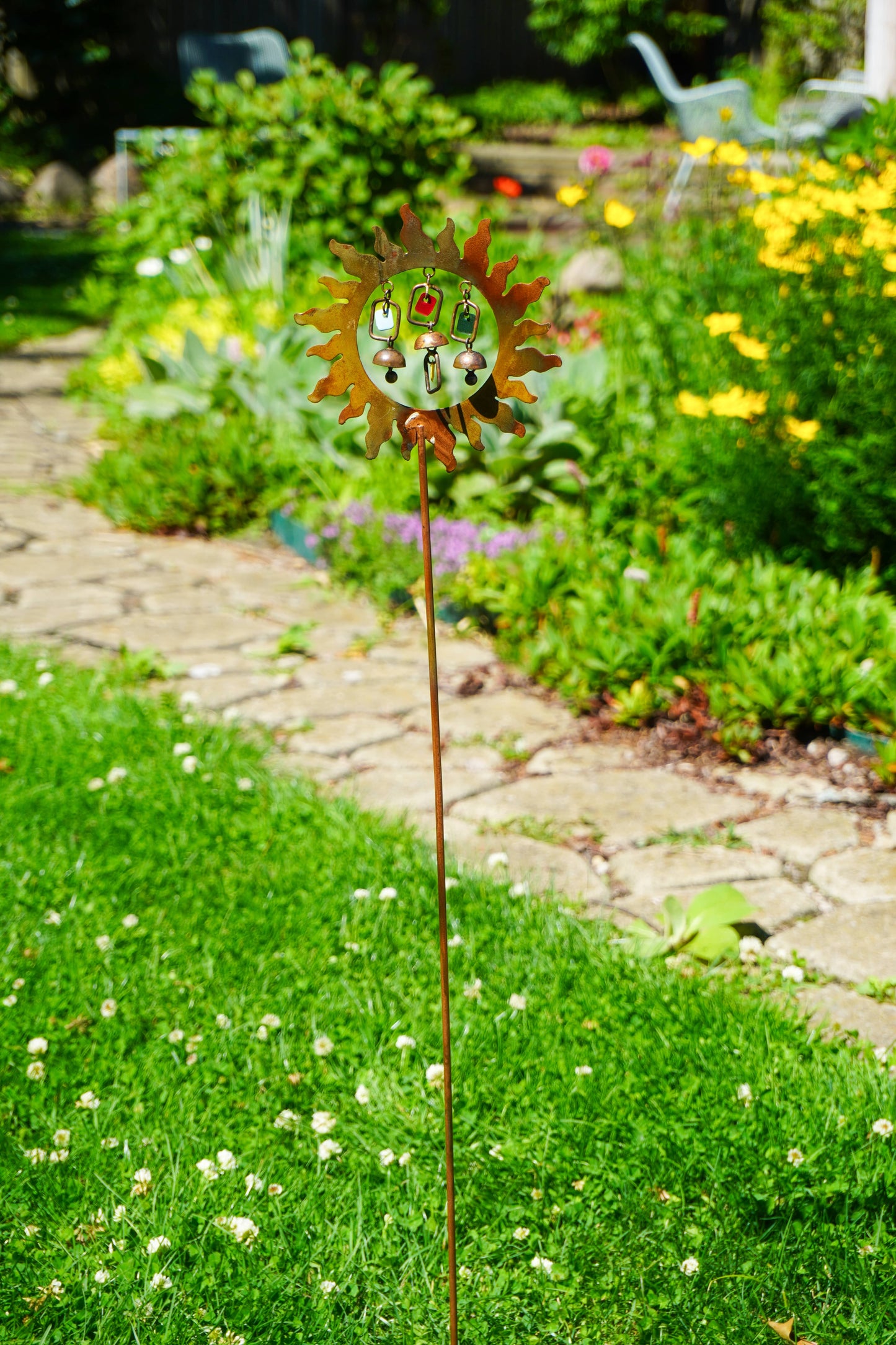 Decorative garden stake with sun design in a garden setting