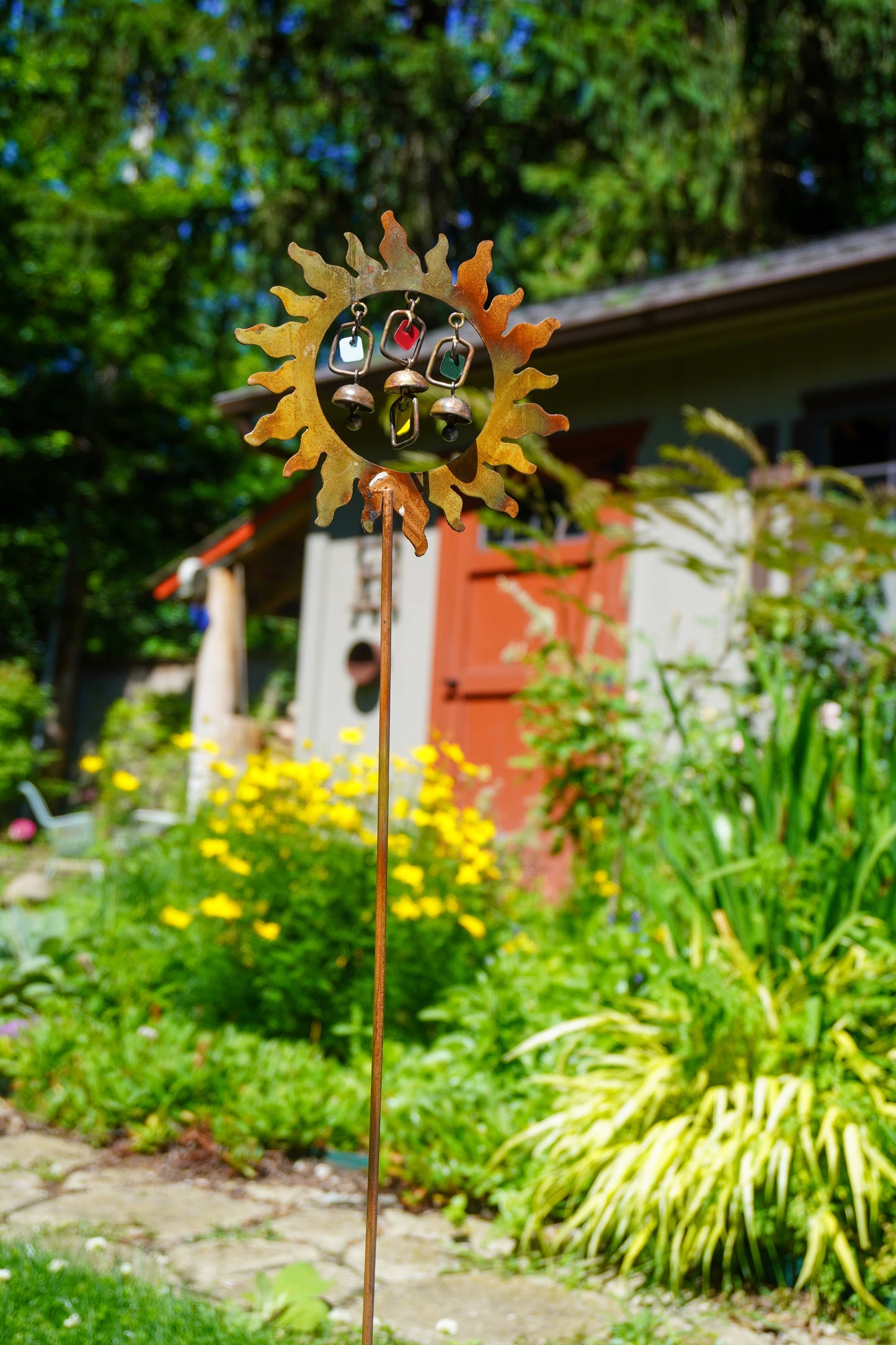 Decorative garden stake with sun design in a garden setting