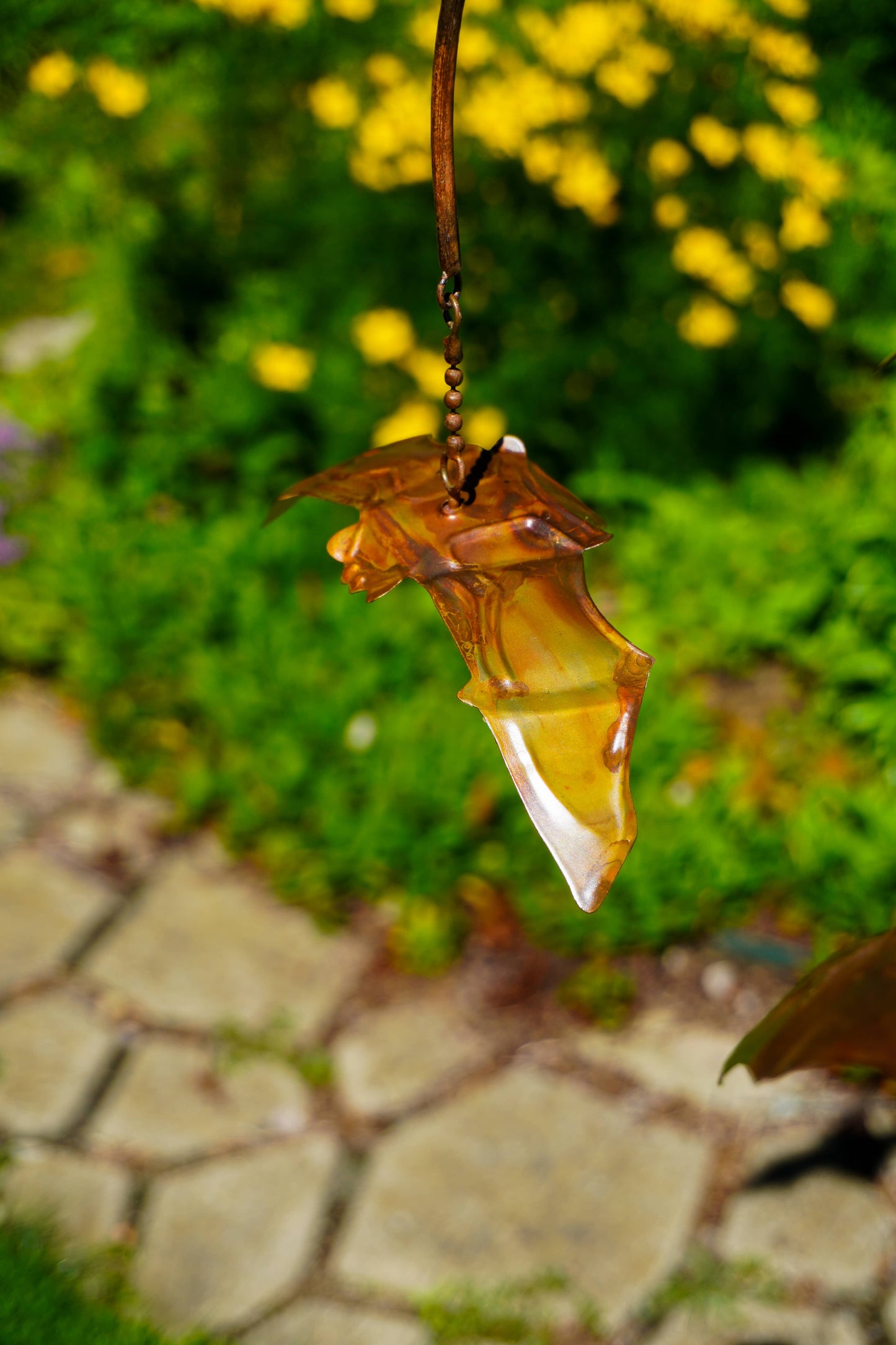 Rustic metal hanging mobile with layered arched arms and small copper-toned bat figurines suspended by chains