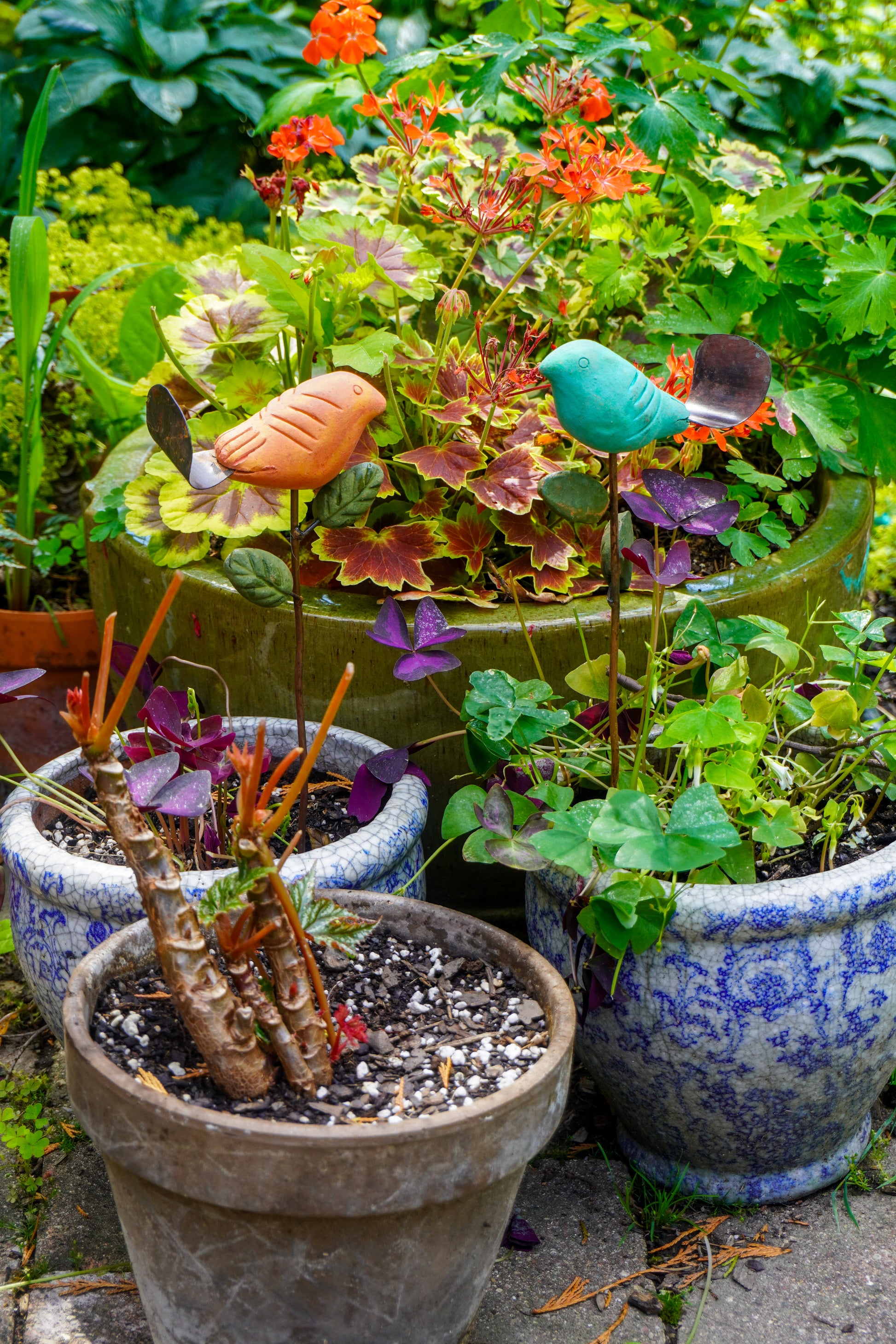 Colorful garden stakes with plants and decorative elements on a patio