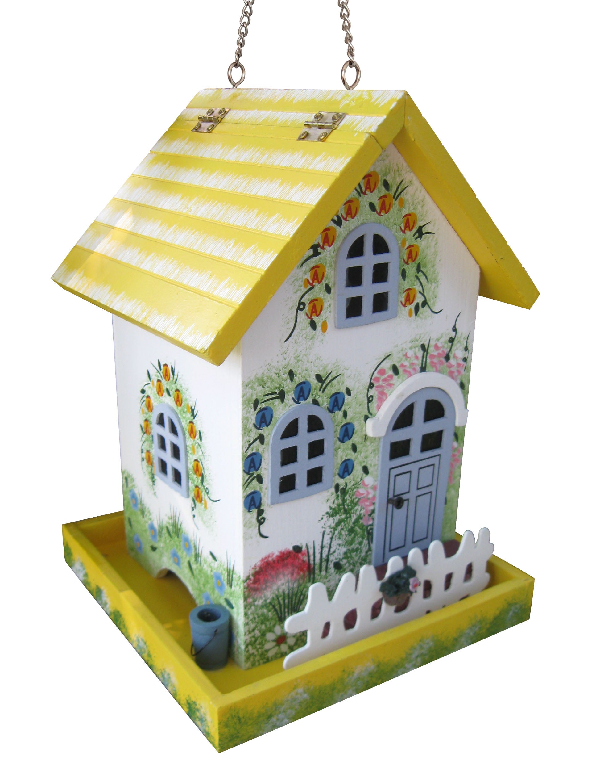 A decorative hanging bird feeder shaped like a small house, with a yellow-and-white striped roof, white body, painted floral and garden details, a blue door, and a yellow feeder tray at the bottom.