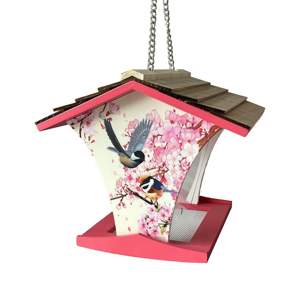 A hanging bird feeder with a pink cherry blossom floral print, featuring two birds, a wooden roof, and a pink base, shown against a plain white background.