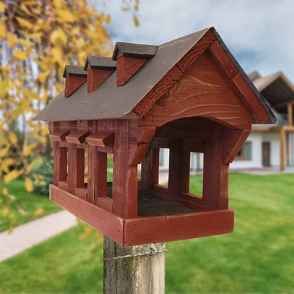 Wooden birdhouse on a post with a blurred garden background