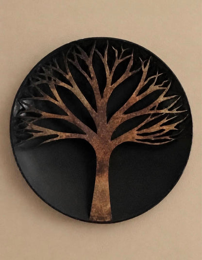 Round black metal wall disc with a raised copper-toned bare tree silhouette branching across the upper half