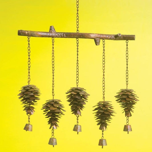 Rustic metal wind chime with pine cone clusters and small brass bells hanging from a branch-shaped bar on a pergola
